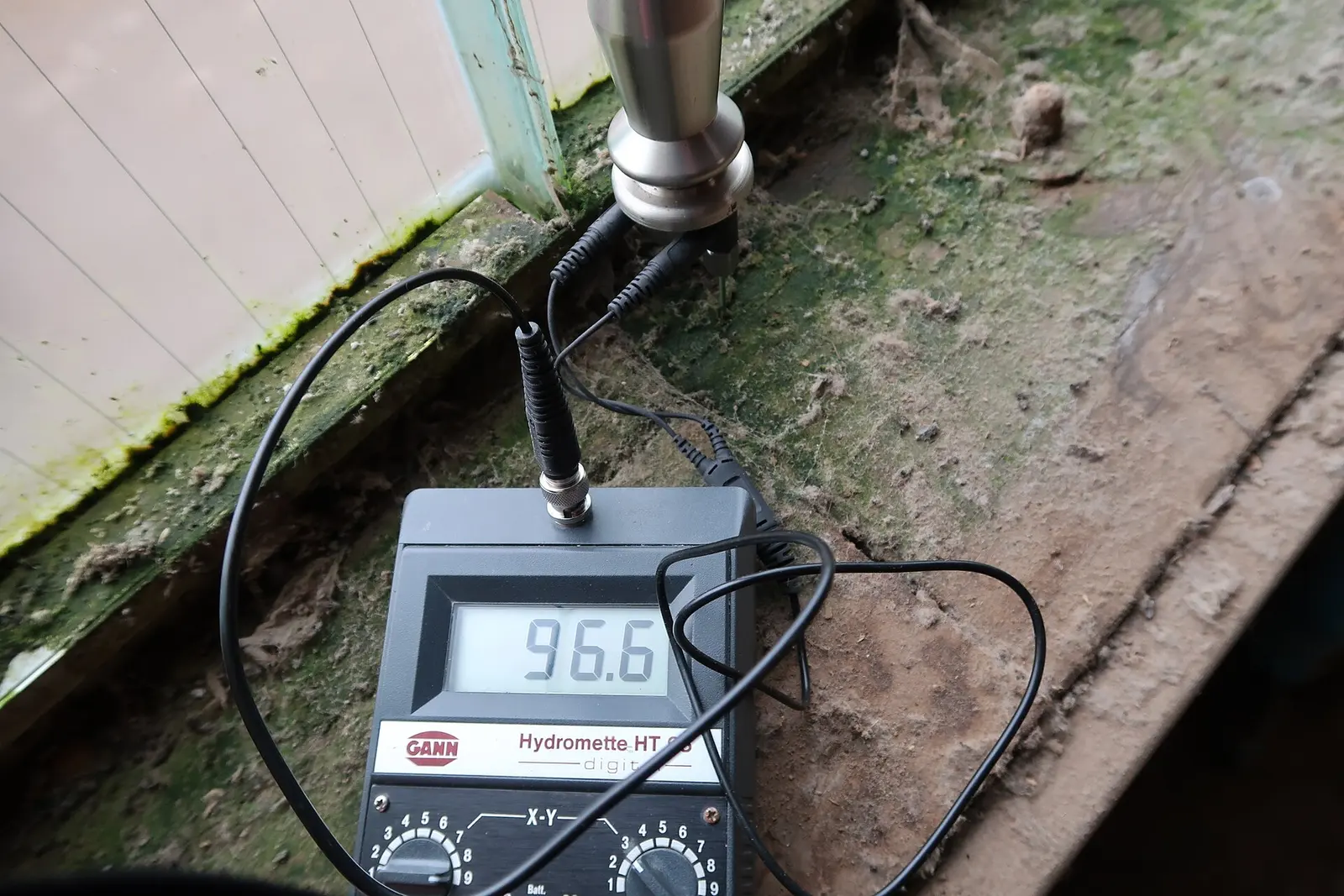 A moisture meter probing a moldy wood windowsill. Shown on the Mold testing page for Albany, NY.